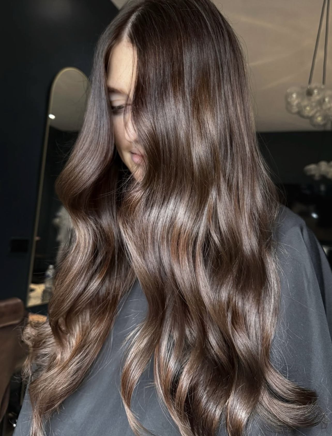 Long brunette hair with glossy loose waves, styled by Hailey